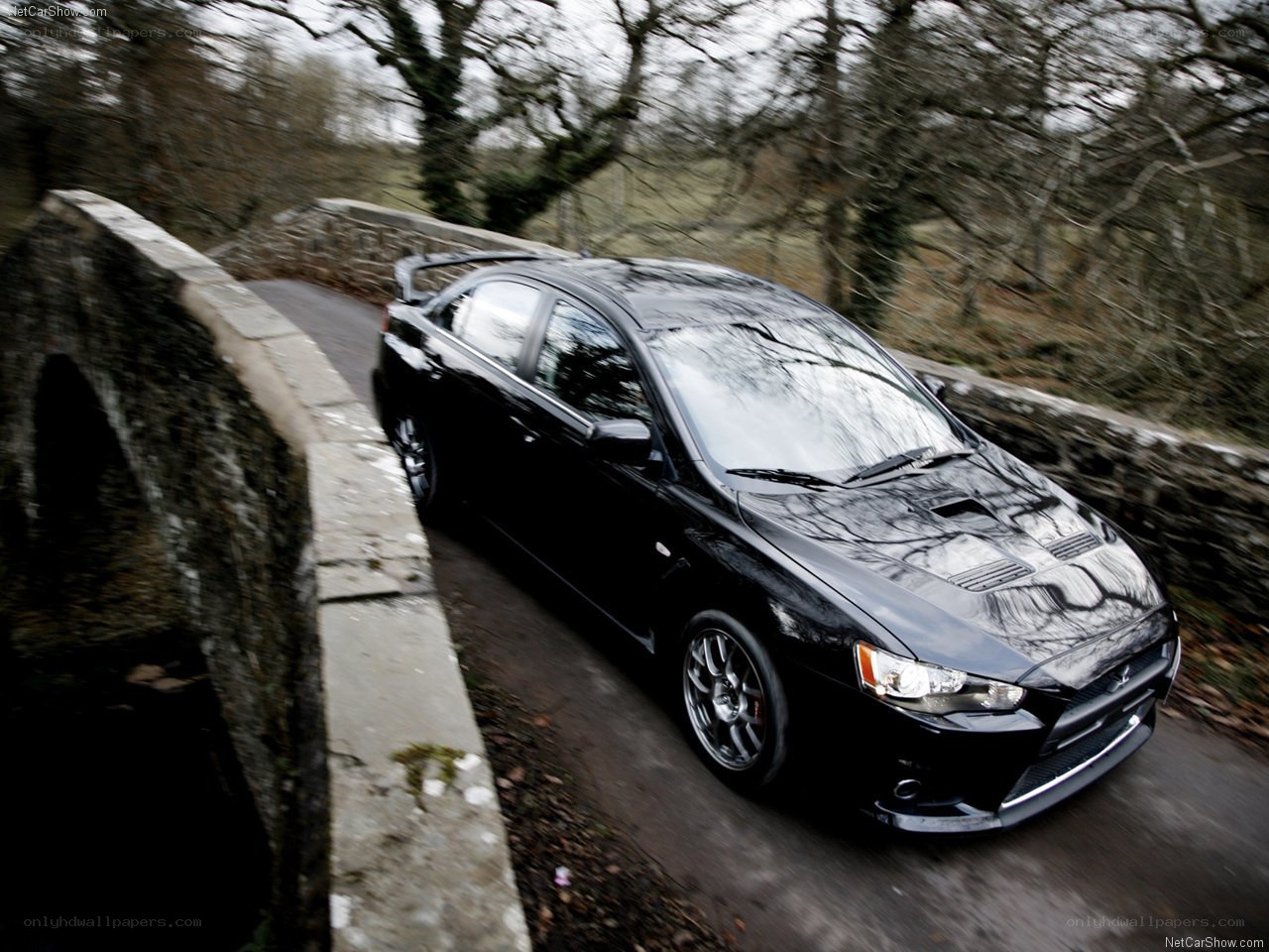 black mitsubishi lancer evolution on a bridge