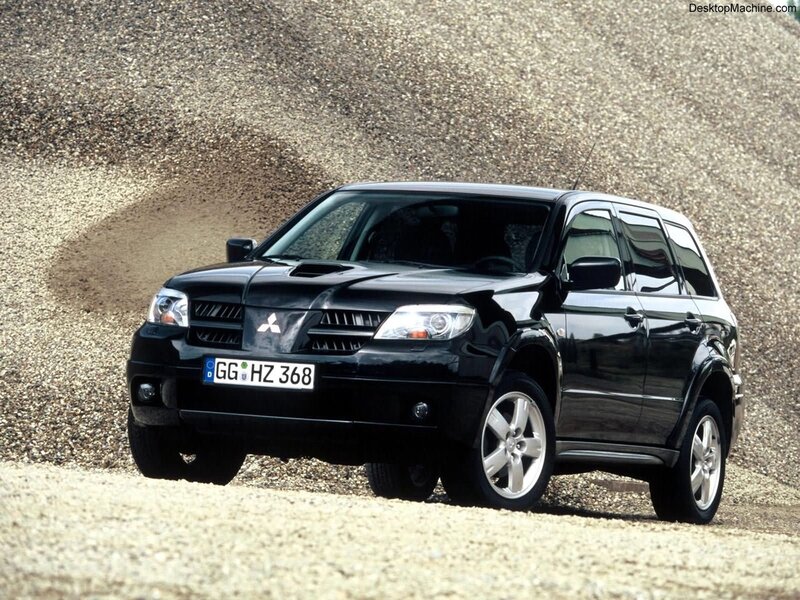 black mitsubishi suv on gravel