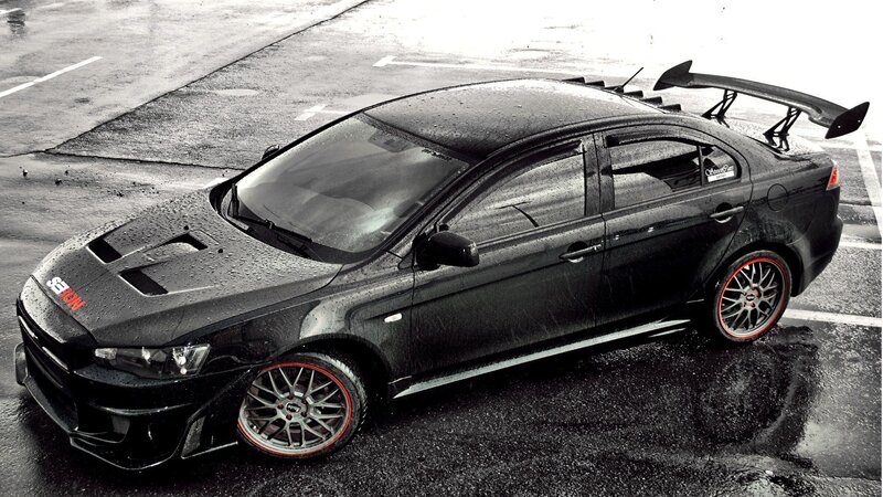 Black Modified Sedan — Dramatic, Photograph, Wet Pavement, Rear Wing, Red Accents