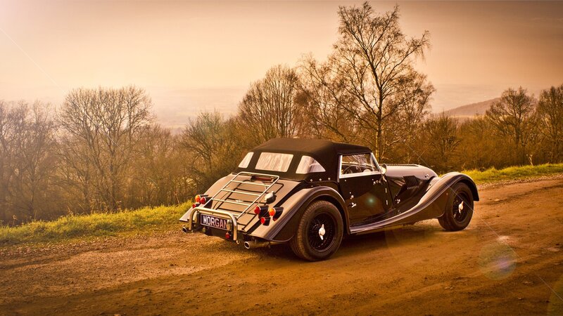 Black Morgan car on dirt road