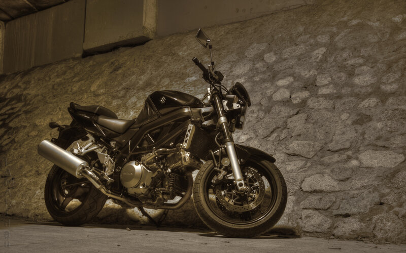 Black motorcycle against stone wall