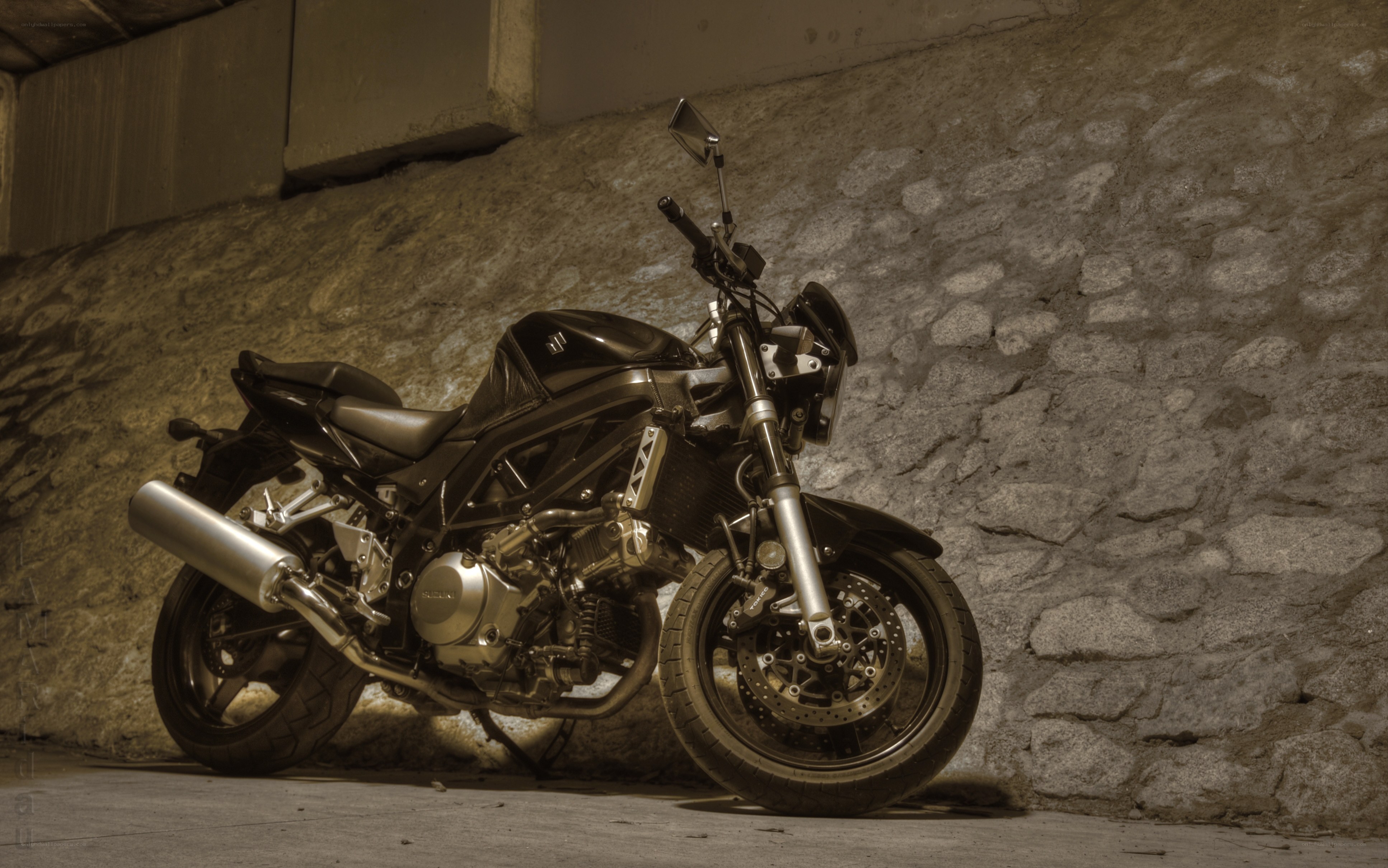 Black motorcycle against stone wall