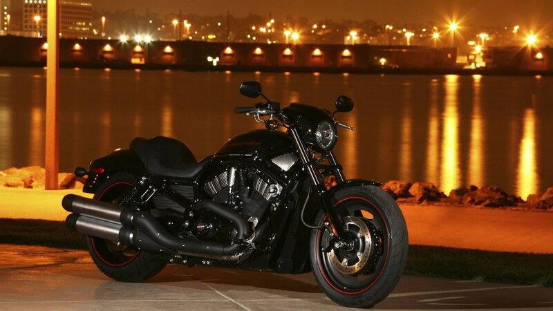 Black motorcycle at night by water