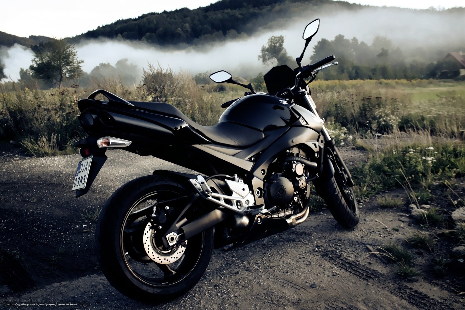 Black motorcycle in misty field