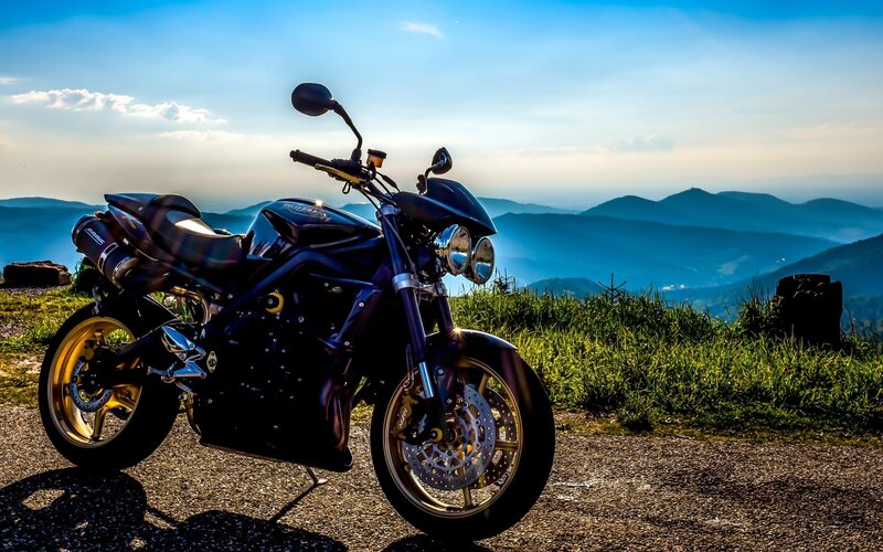 Black Motorcycle on Hill — Blue