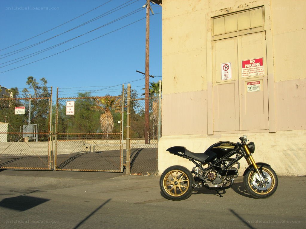Black motorcycle parked by building
