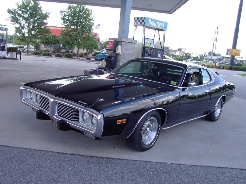 Black muscle car at gas station