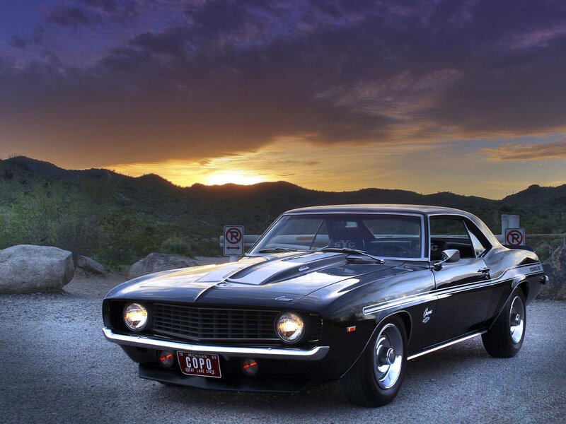 Black muscle car at sunset
