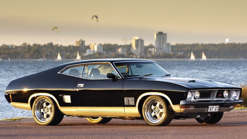 Black muscle car by the water