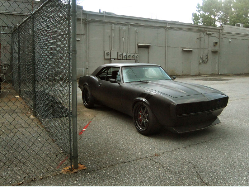 Black Muscle Car — Industrial, Photograph, Chain-link Fence