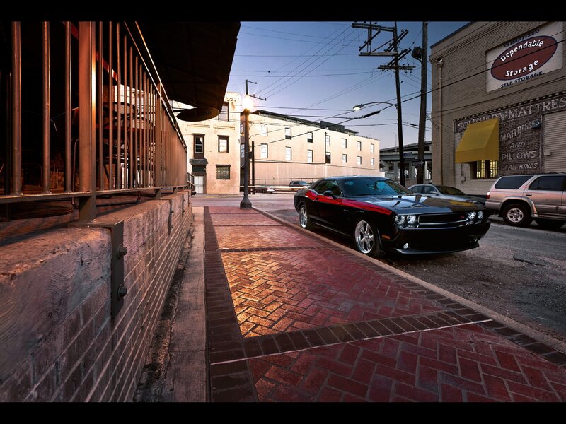 Black muscle car on brick sidewalk