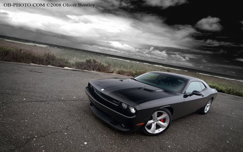 Black muscle car on coastal road