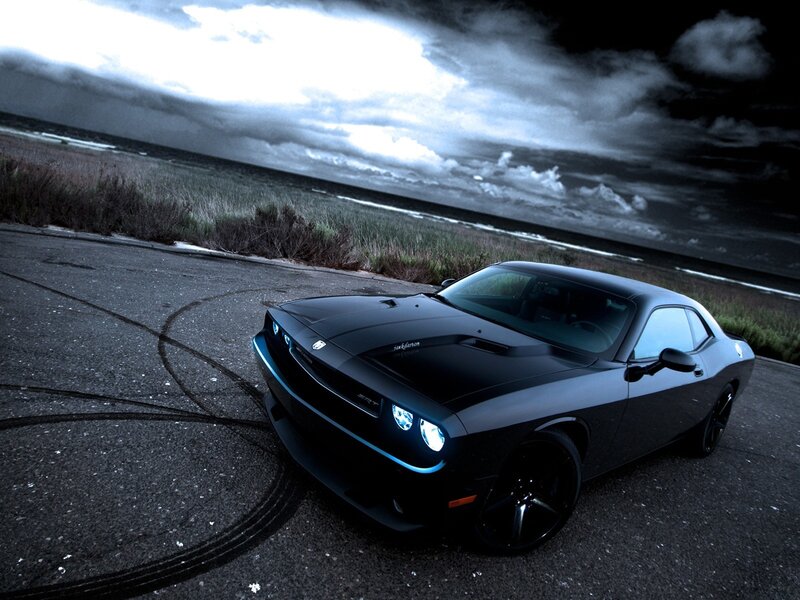 Black muscle car on coastal road
