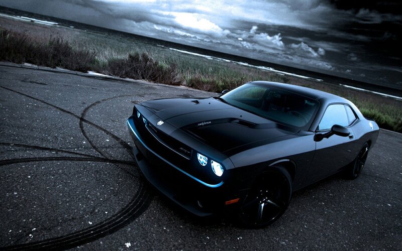 Black muscle car on coastal road