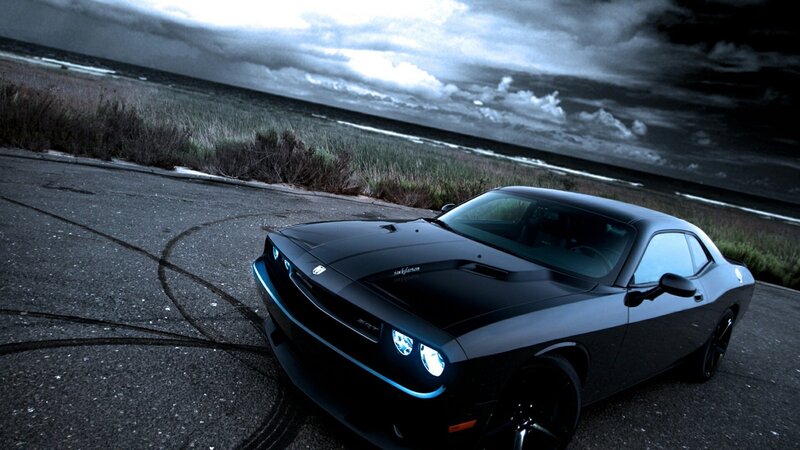 Black muscle car on coastal road