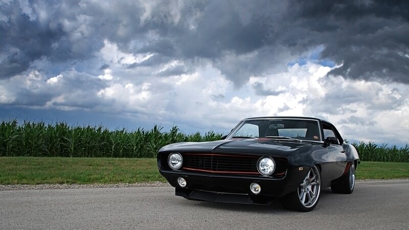 Black muscle car on country road