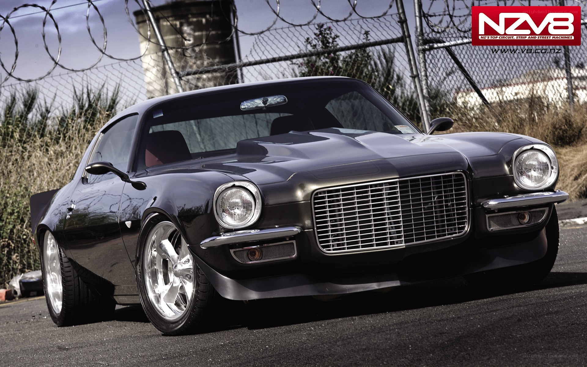 black muscle car with custom wheels