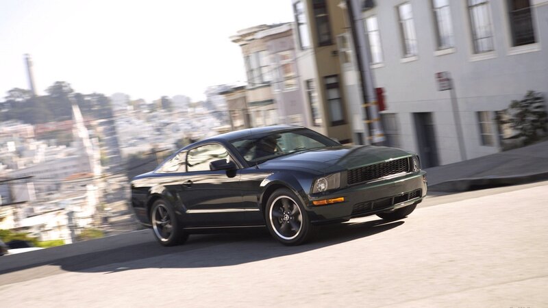 black mustang driving on city street