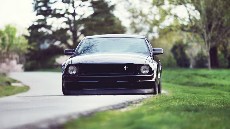 black mustang on a country road