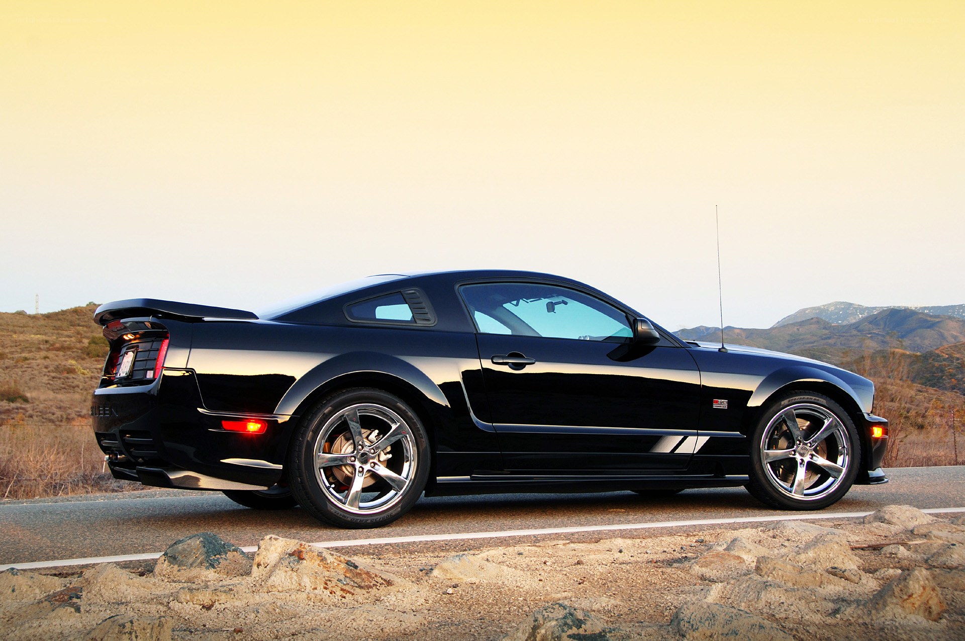 black mustang on mountain road