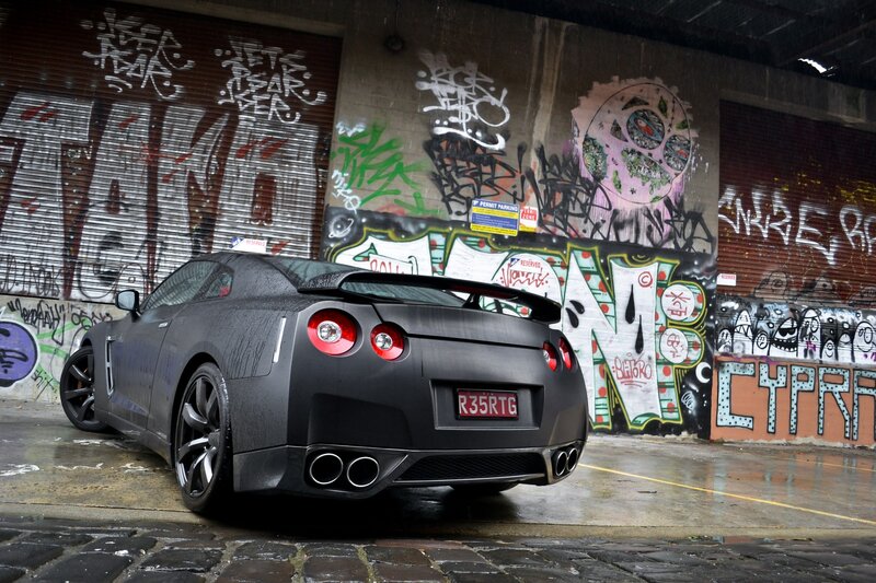 Black Nissan GT-R in graffiti alley
