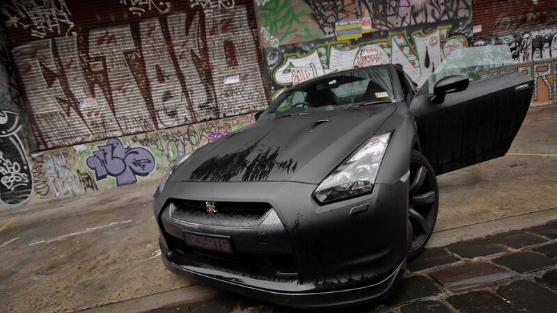 Black Nissan GT-R in graffiti alley