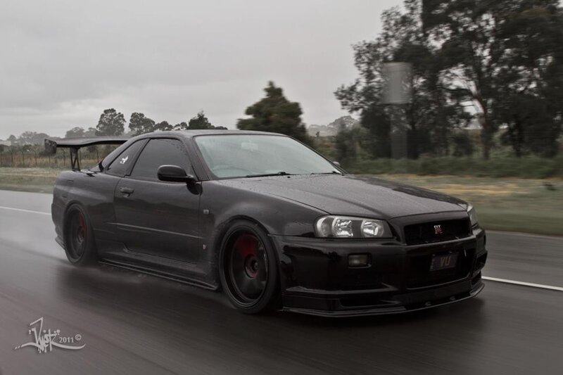 black nissan skyline on wet road