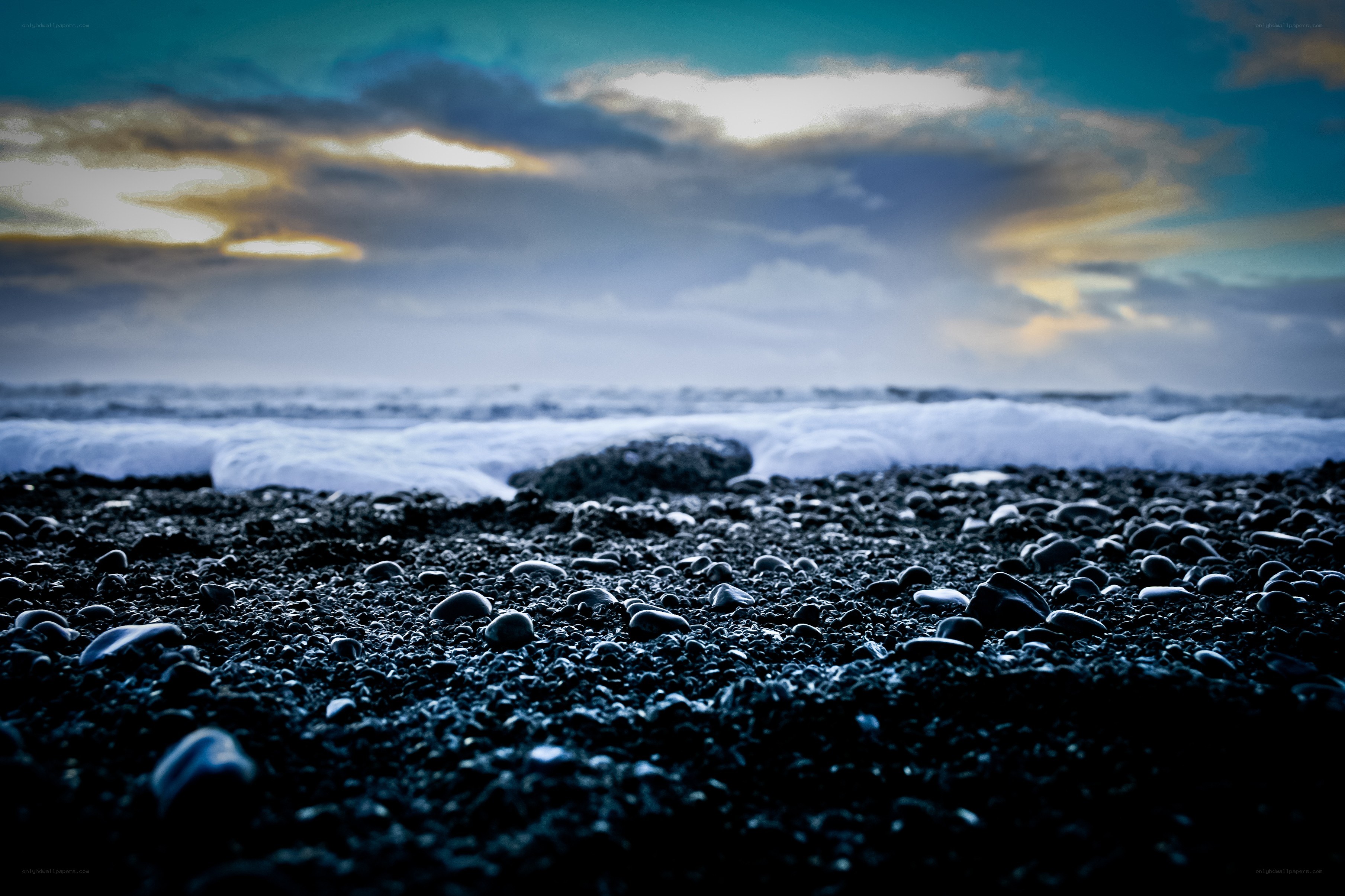 Black pebble beach at sunset