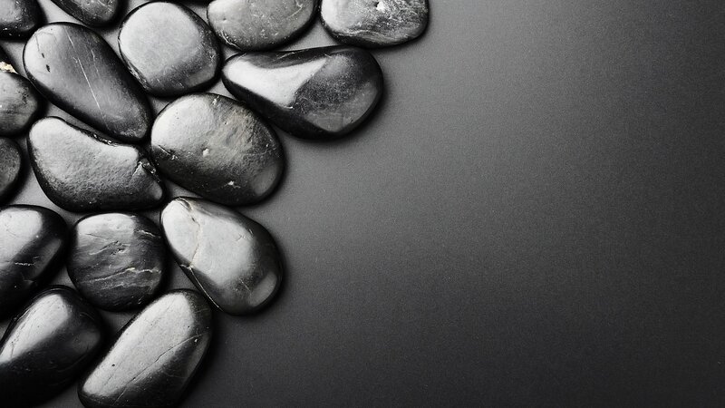 black pebbles on dark surface