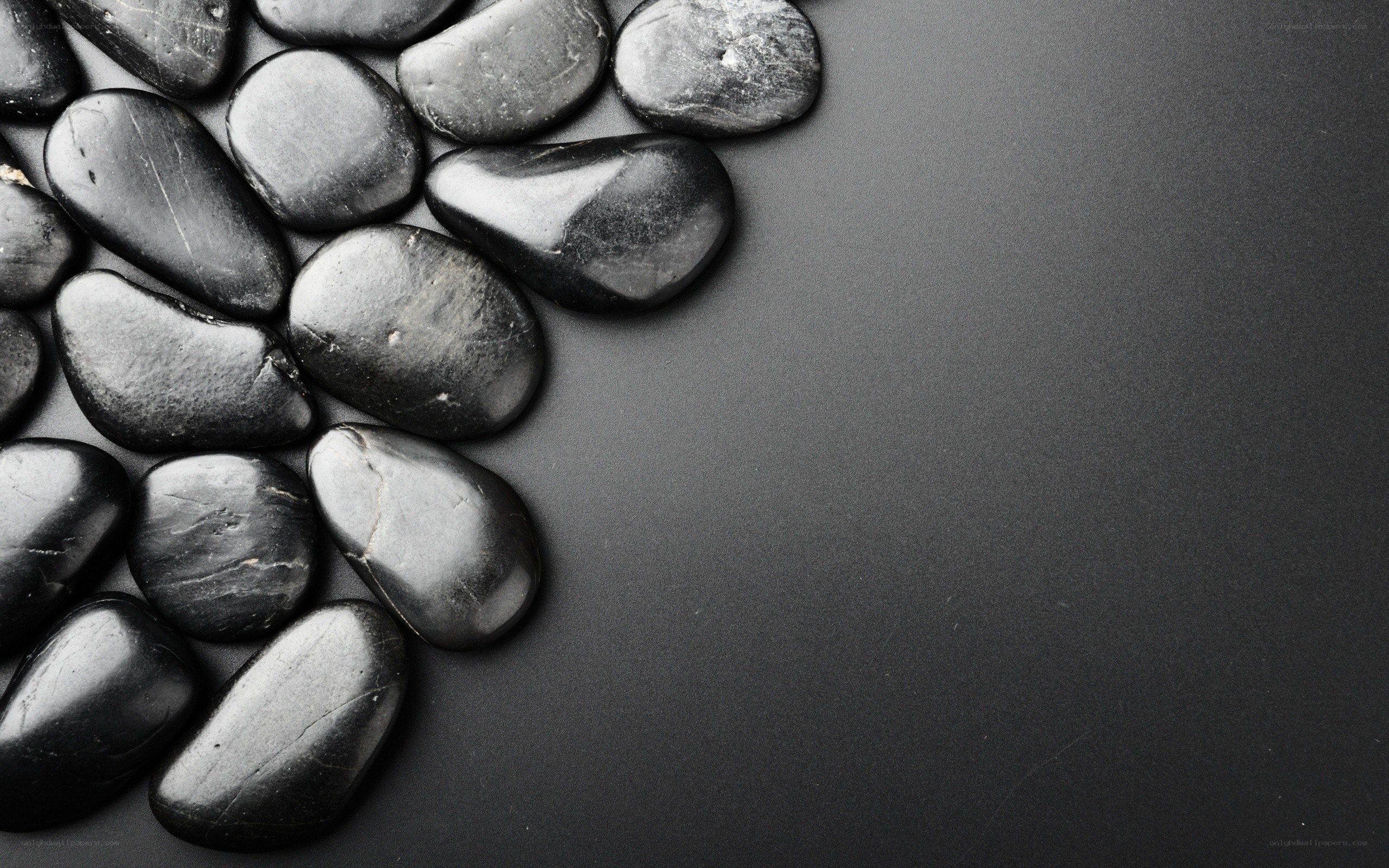 black pebbles on dark surface