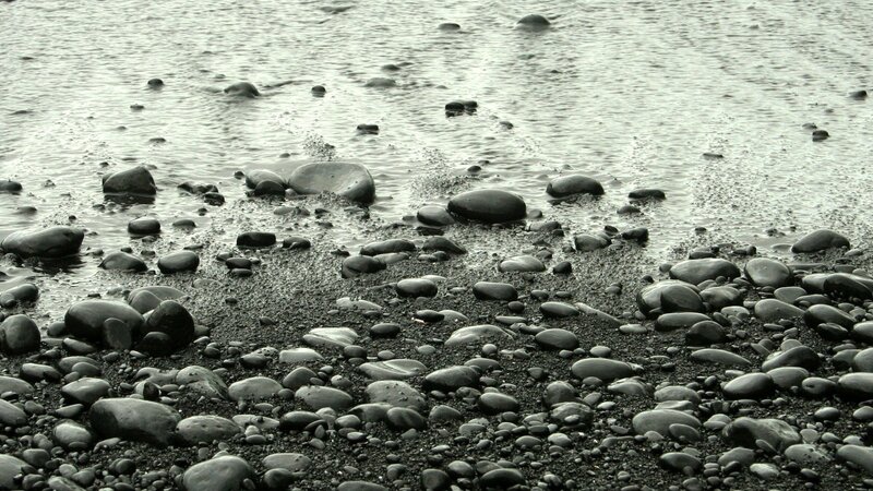 black pebbles on wet beach