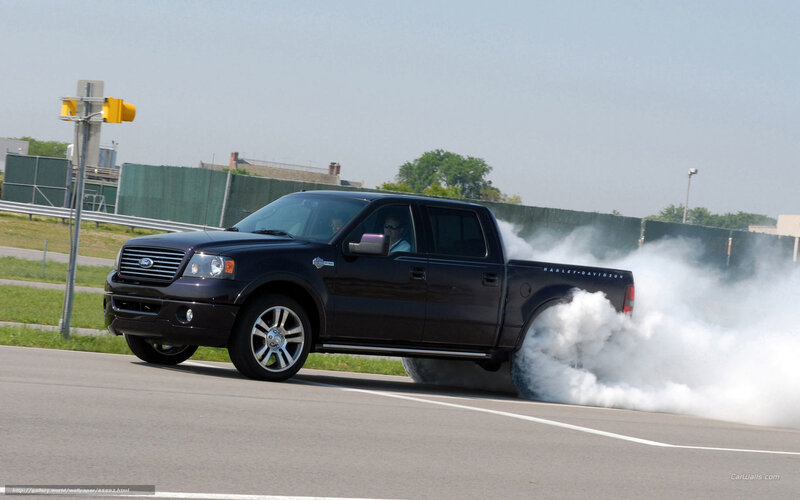 black pickup truck doing burnout