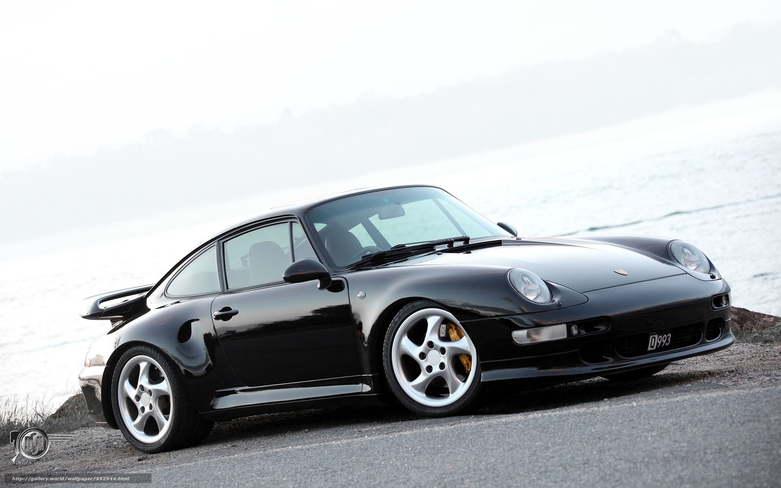 Black Porsche 993 on a coastal road
