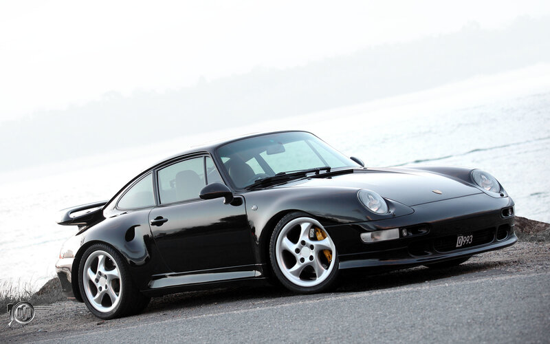 Black Porsche 993 on coastal road