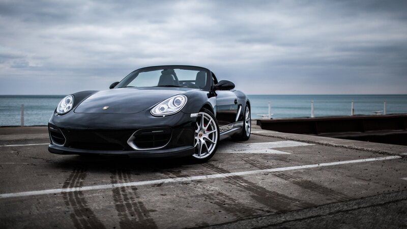 Black Porsche Boxster by the sea