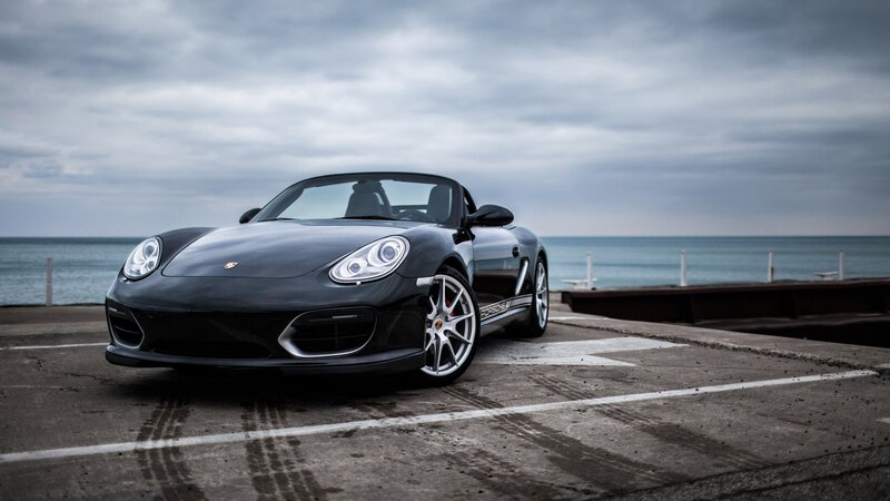 Black Porsche Boxster by the sea