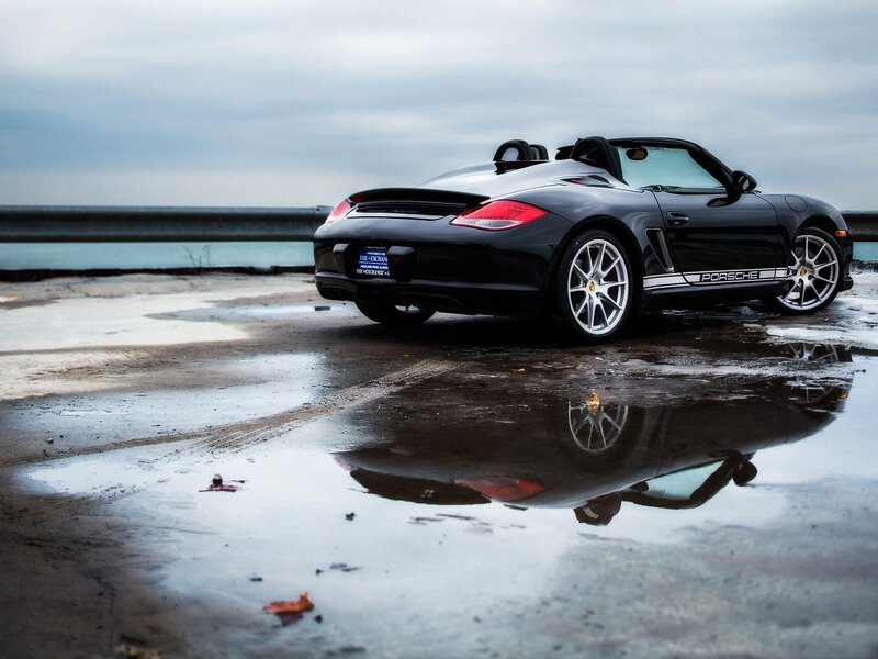 Black Porsche Boxster by the water