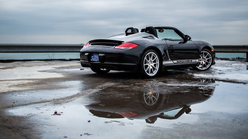 Black Porsche Boxster by the water