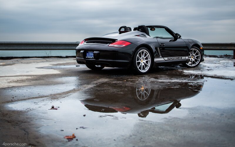 Black Porsche Boxster by the water