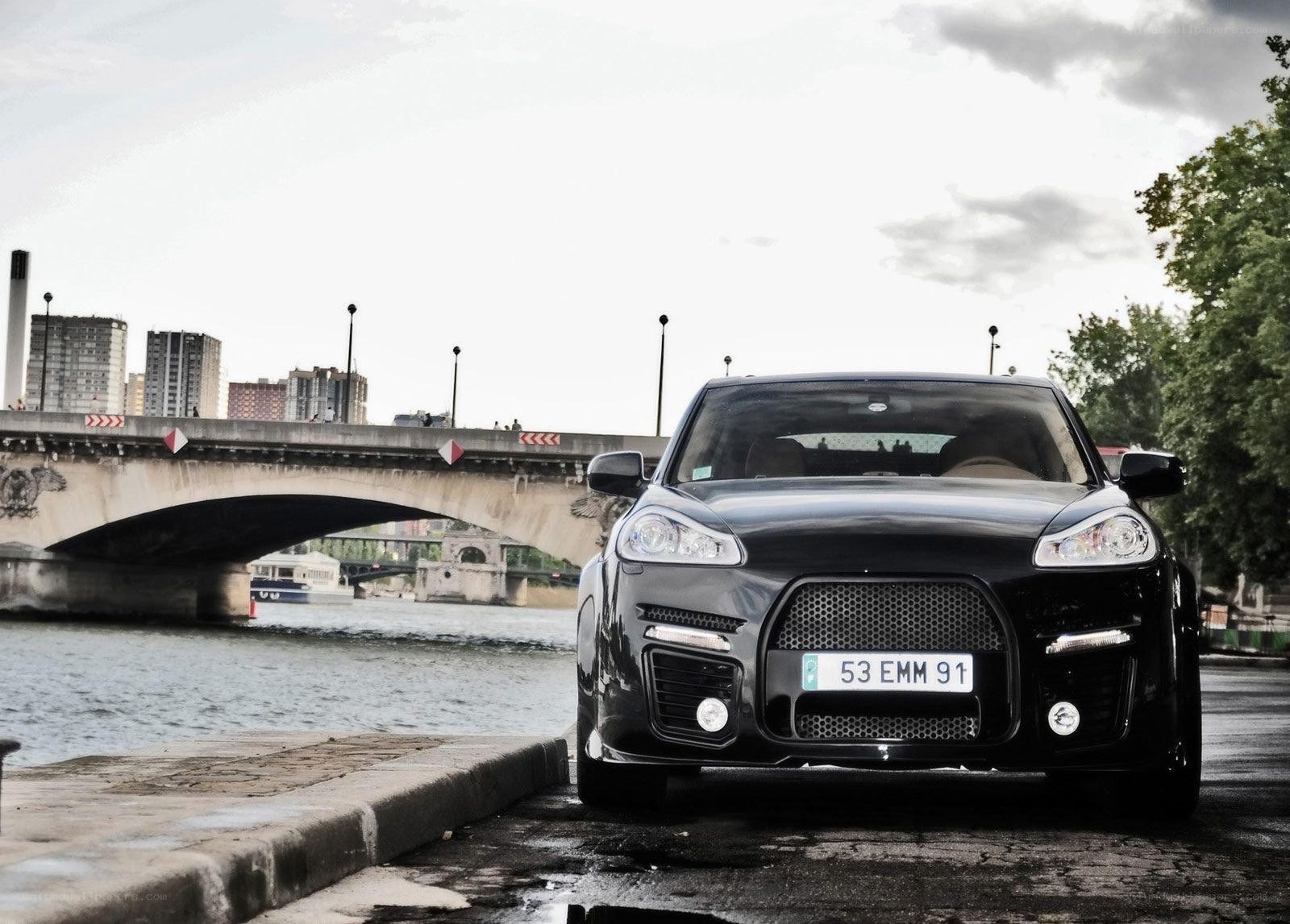 Black Porsche Cayenne by the river