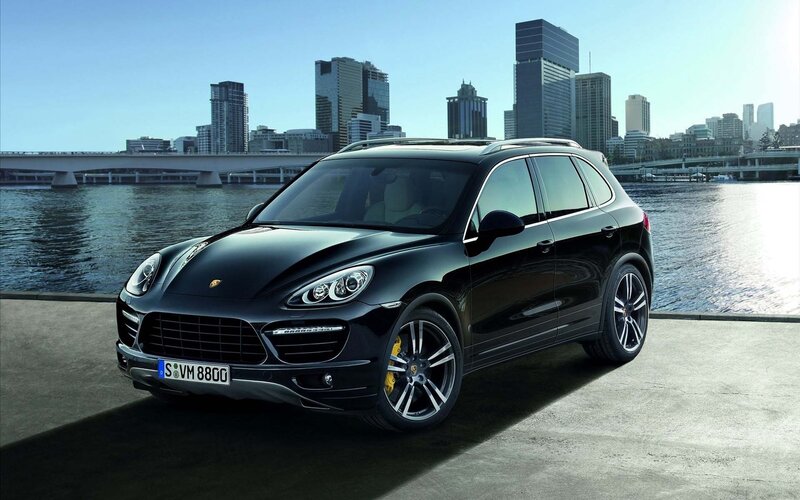 Black Porsche Cayenne by the water