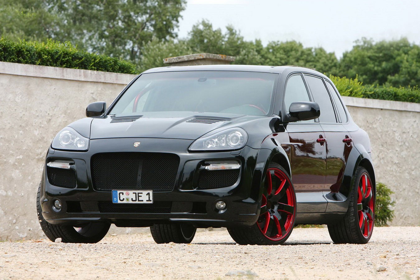 Black Porsche Cayenne with red wheels