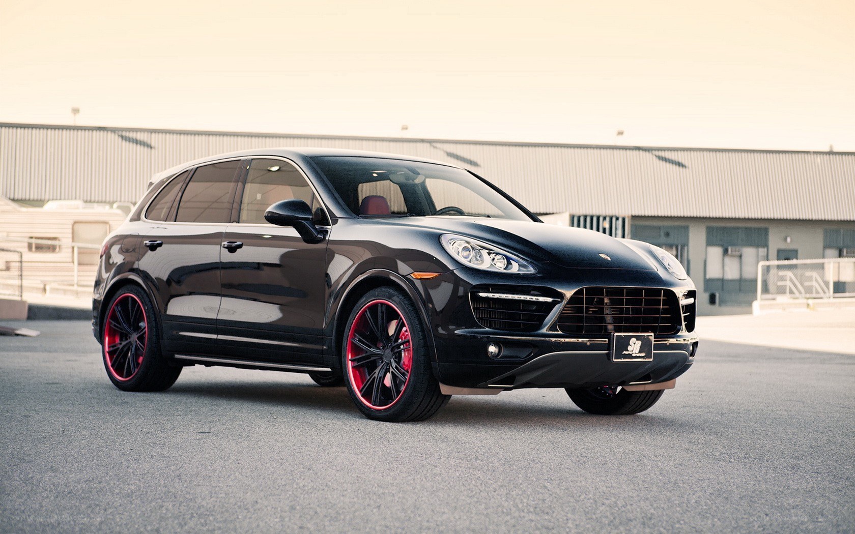 Black Porsche Cayenne with red wheels