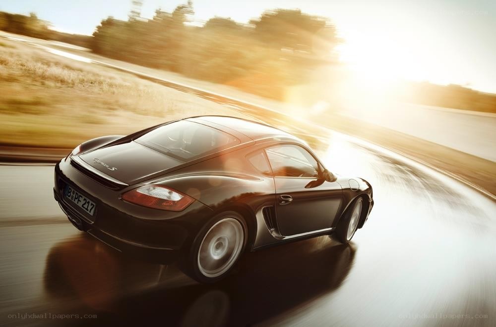 Black Porsche Cayman S in motion