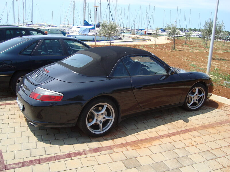 Black Porsche convertible at marina