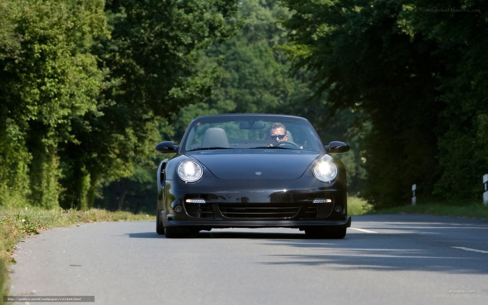 Black Porsche convertible on a road