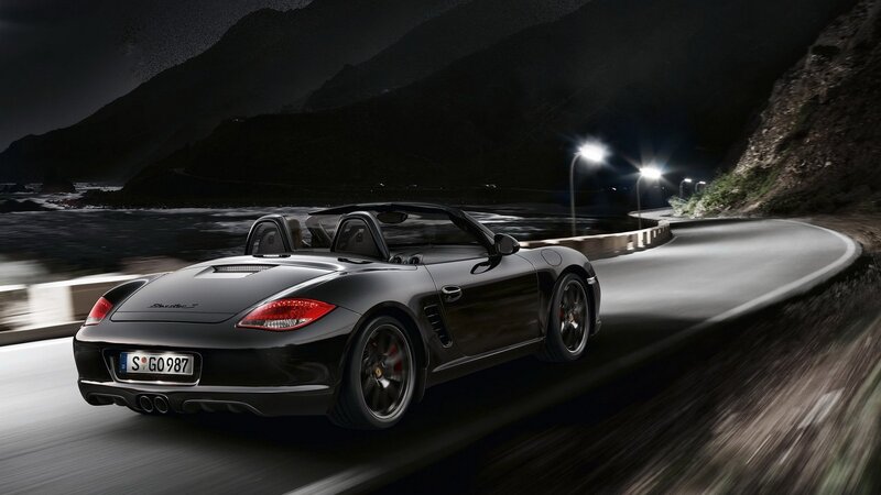 Black Porsche convertible on coastal road