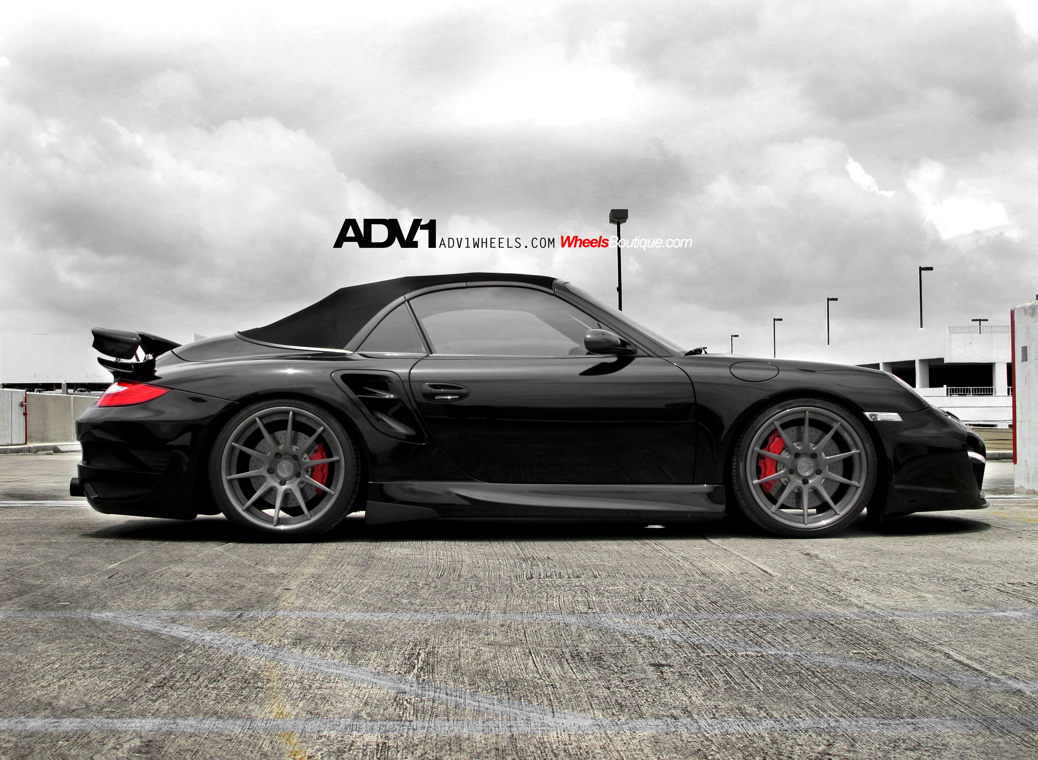 Black Porsche convertible with custom wheels