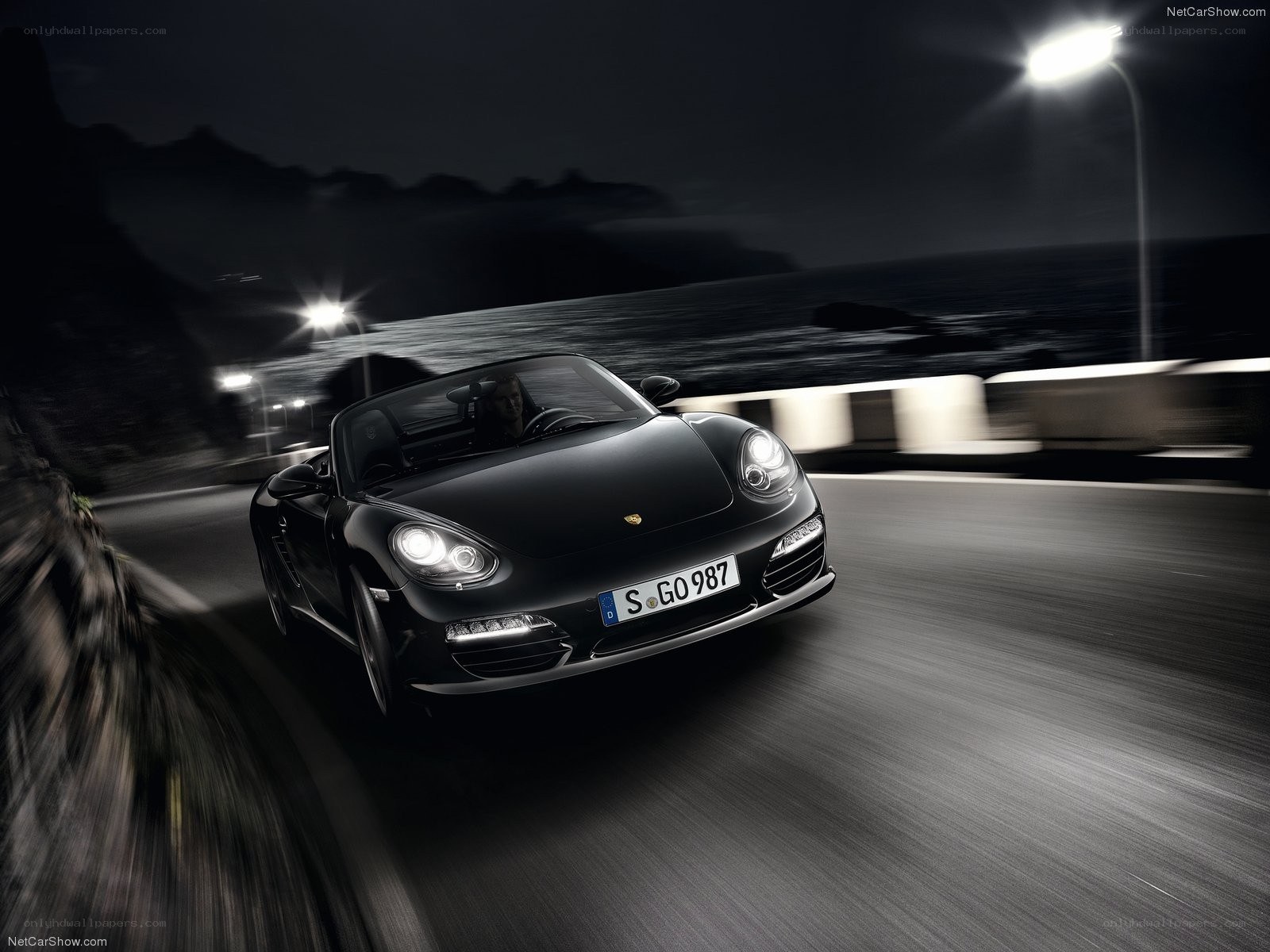 Black Porsche driving at night