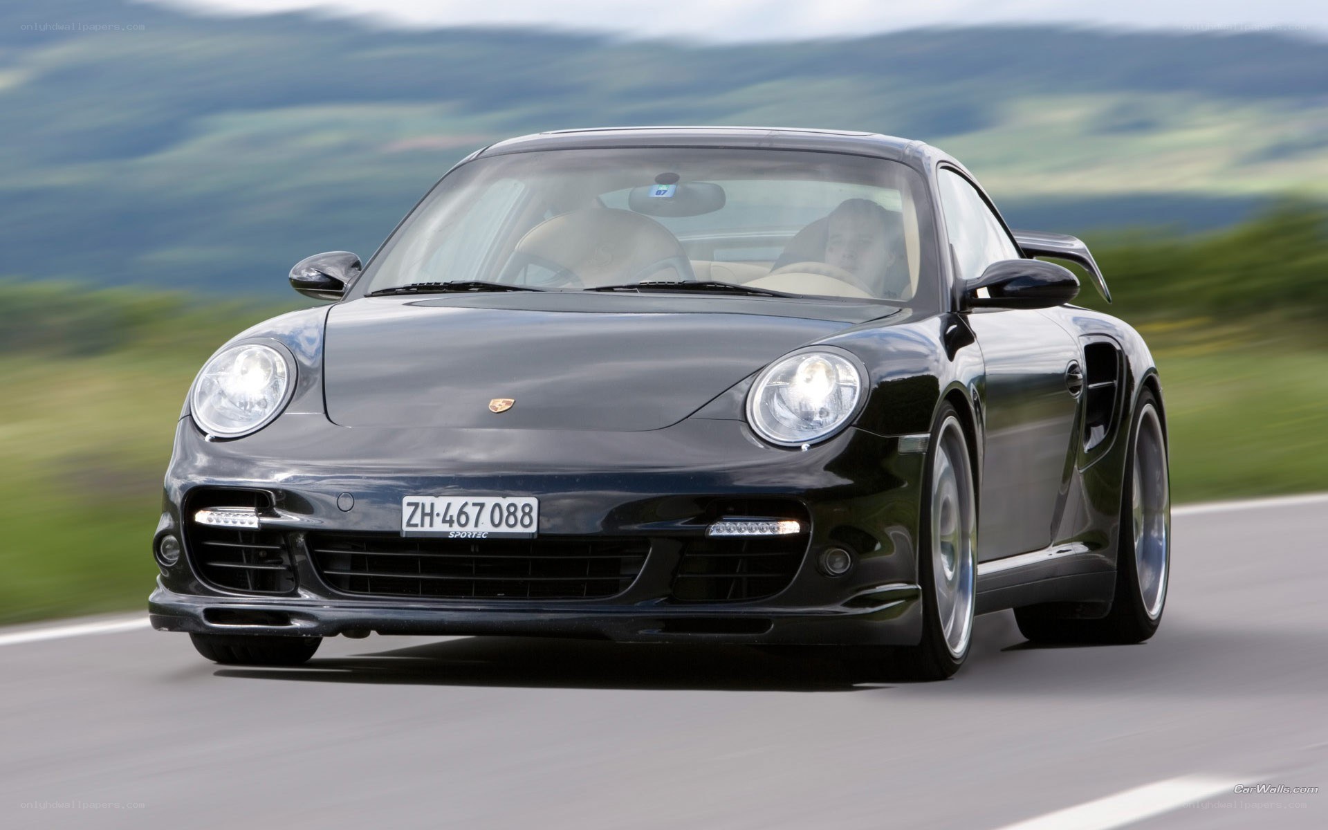 Black Porsche driving on road